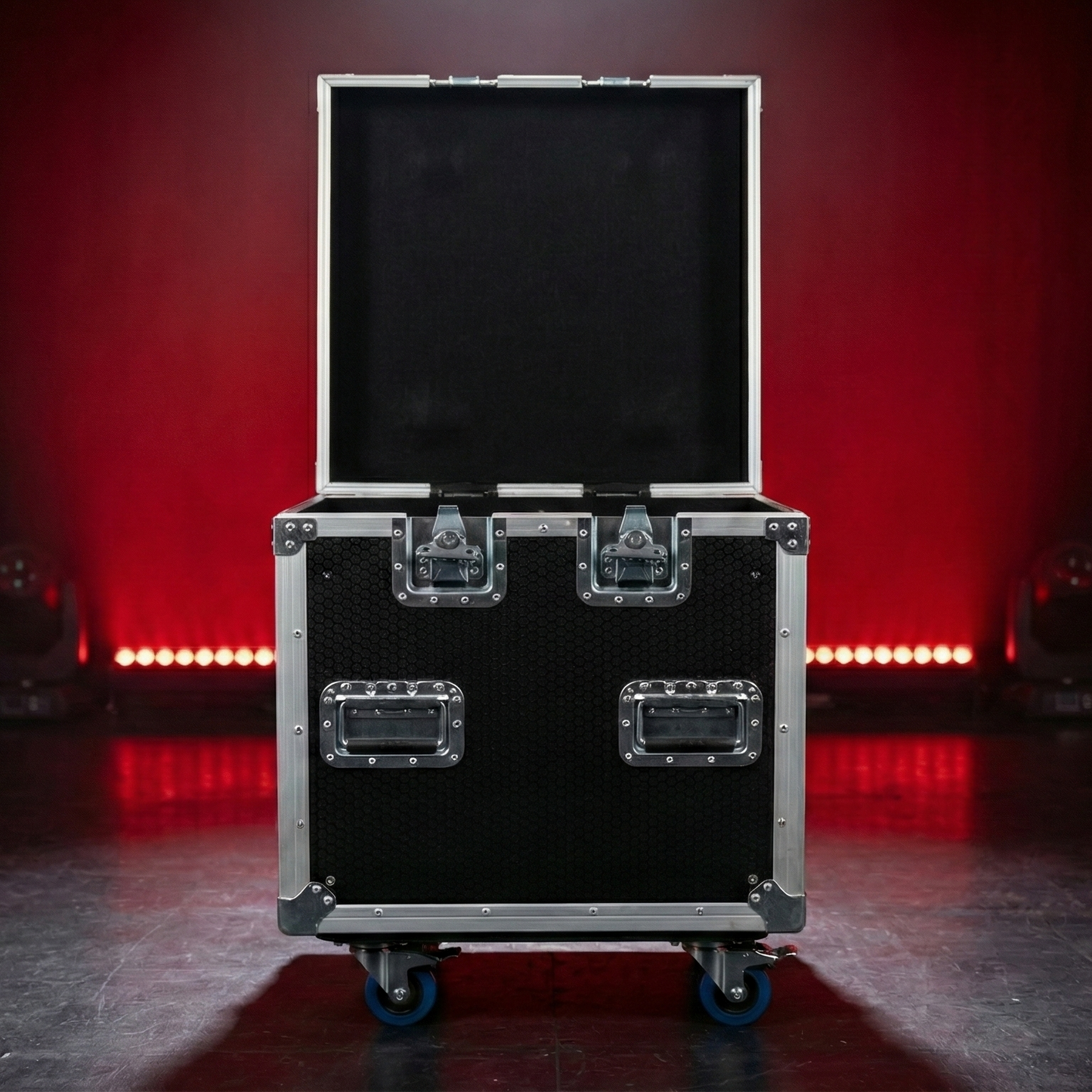 Black flight case on wheels with red stage lights in the background